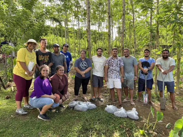 Group of people posing with soil samples and shovels.