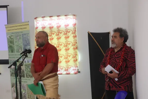 Two people presenting at a microphone.
