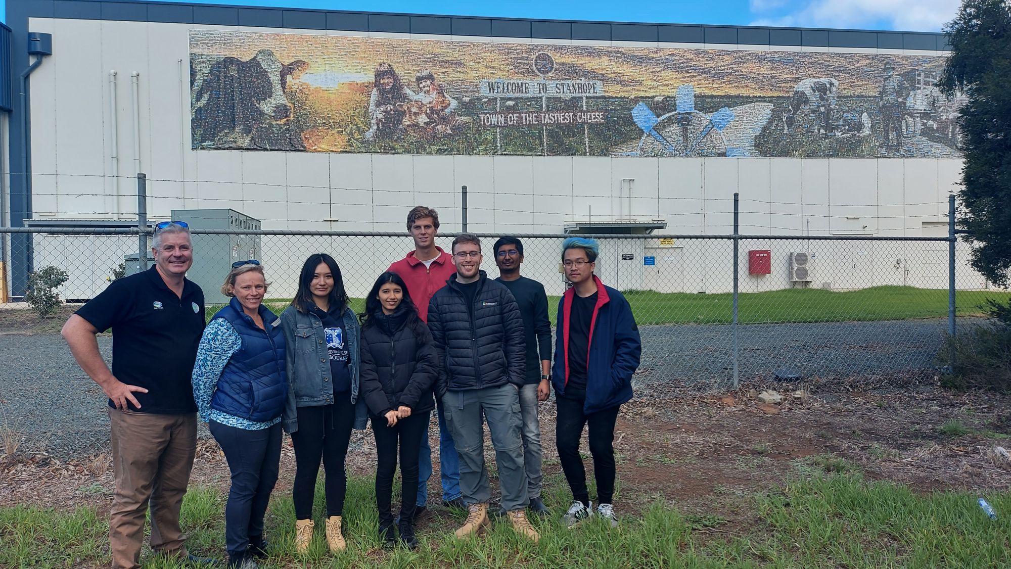 Interns in front of Fonterra factory mural