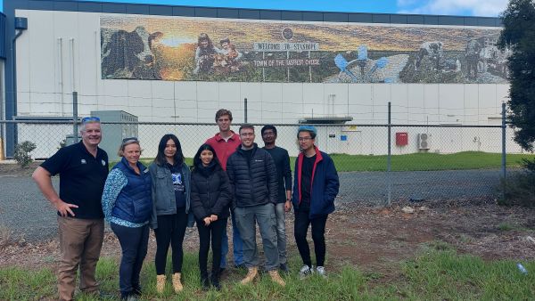Interns in front of Fonterra factory mural