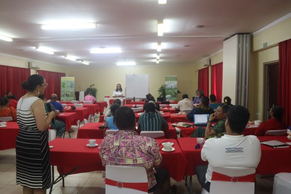 People sitting at tables in a workshop.