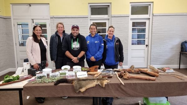 Dr Gupta standing behind a table full of ingredients with 4 other people