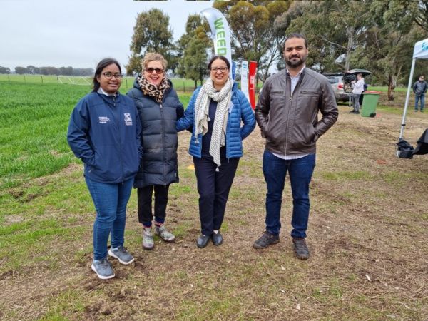 Four people posing together in a paddock