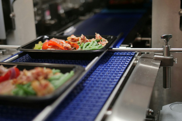 Container full of food on conveyer.
