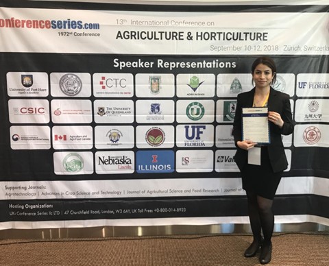 Woman stands in front of conference banner