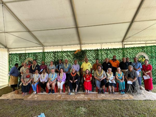 30 people sitting in two tiered rows posing for photograph